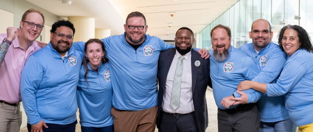 photo of the ACPA27 steering team hugging each other and smiling at the camera